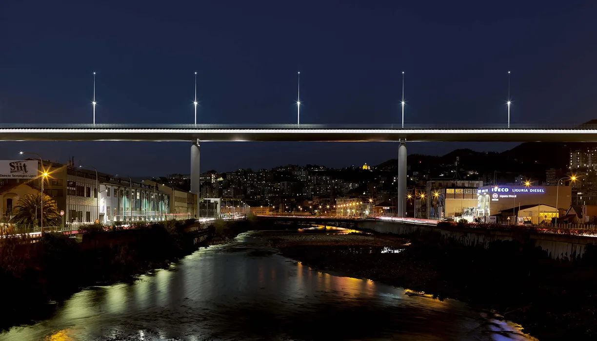 A bridge over a river in a city at night