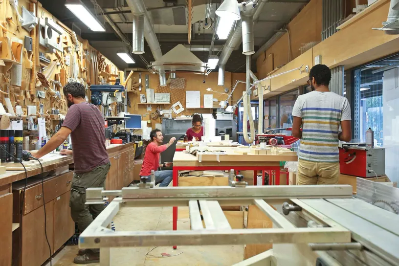 A group of people are working in a woodworking shop