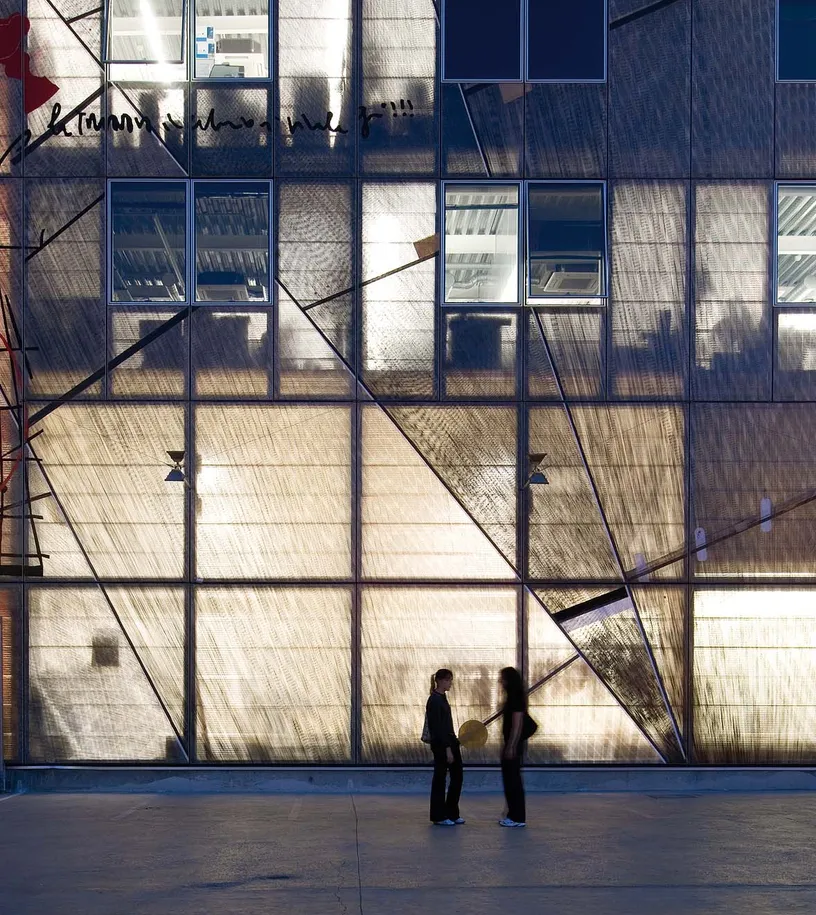 Two people are standing in front of a building