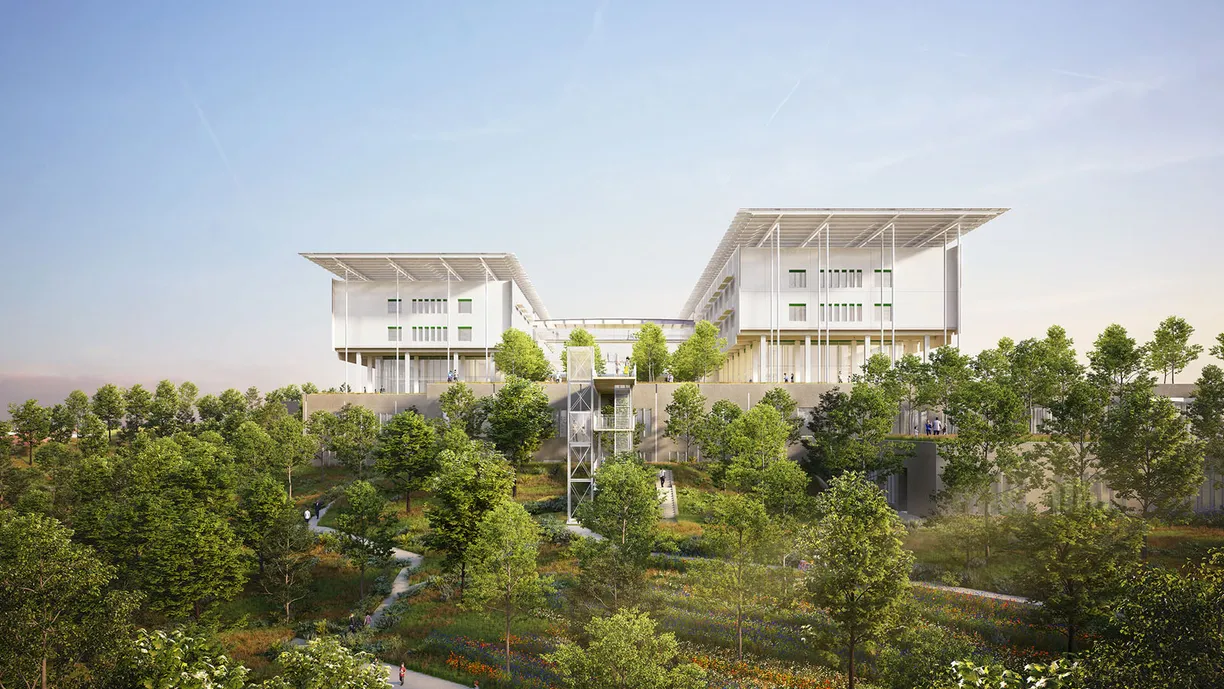 a large white building is sitting on top of a hill surrounded by trees .