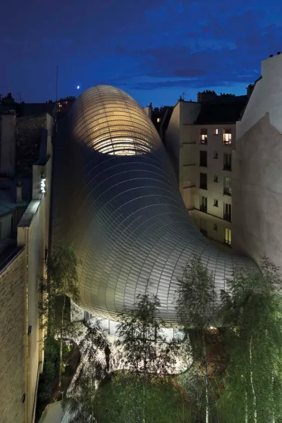 A building with a curved roof is lit up at night