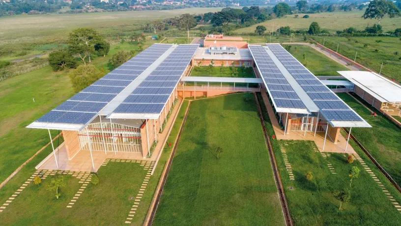 An aerial view of a large building with solar panels on the roof