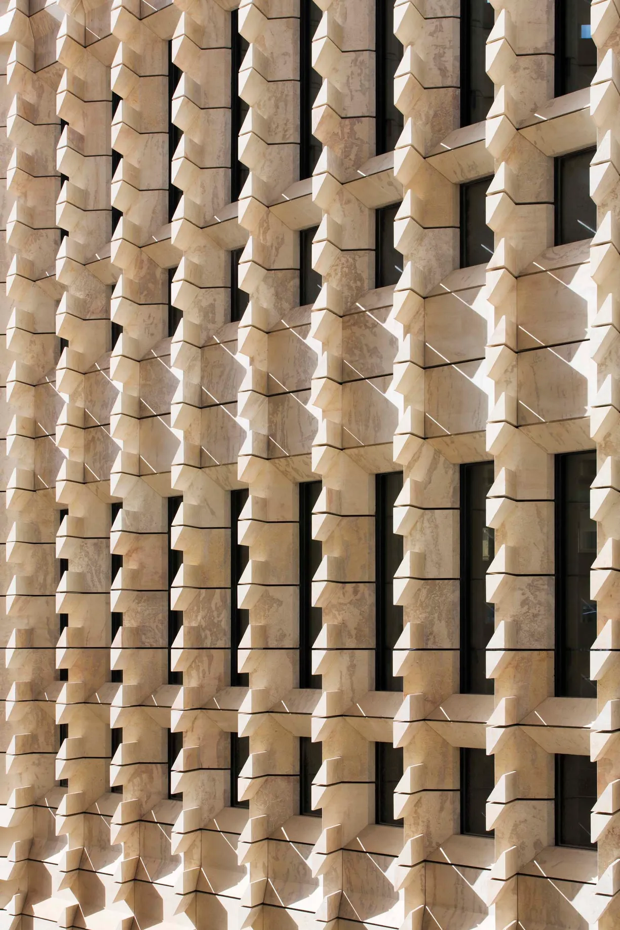 a building with a geometric pattern of bricks and windows