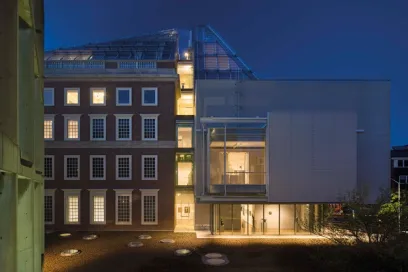 A large building with a lot of windows is lit up at night