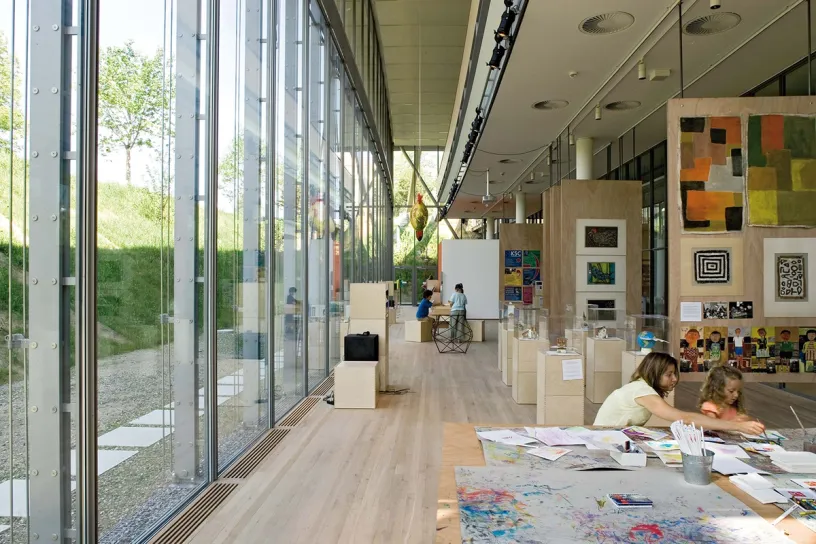 A woman and a child are sitting at a table in a museum