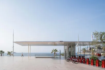 A man is walking in front of a building with bicycles parked in front of it