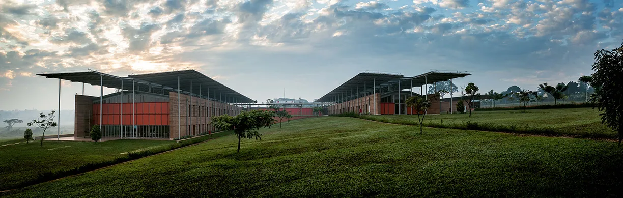 A large building is sitting on top of a lush green hillside