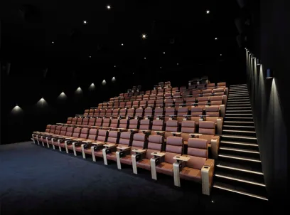 A large auditorium with rows of seats and stairs in a movie theater