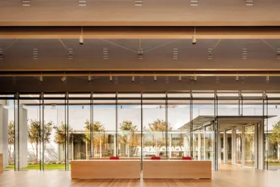 A large room with a lot of windows and a wooden table in the middle of it