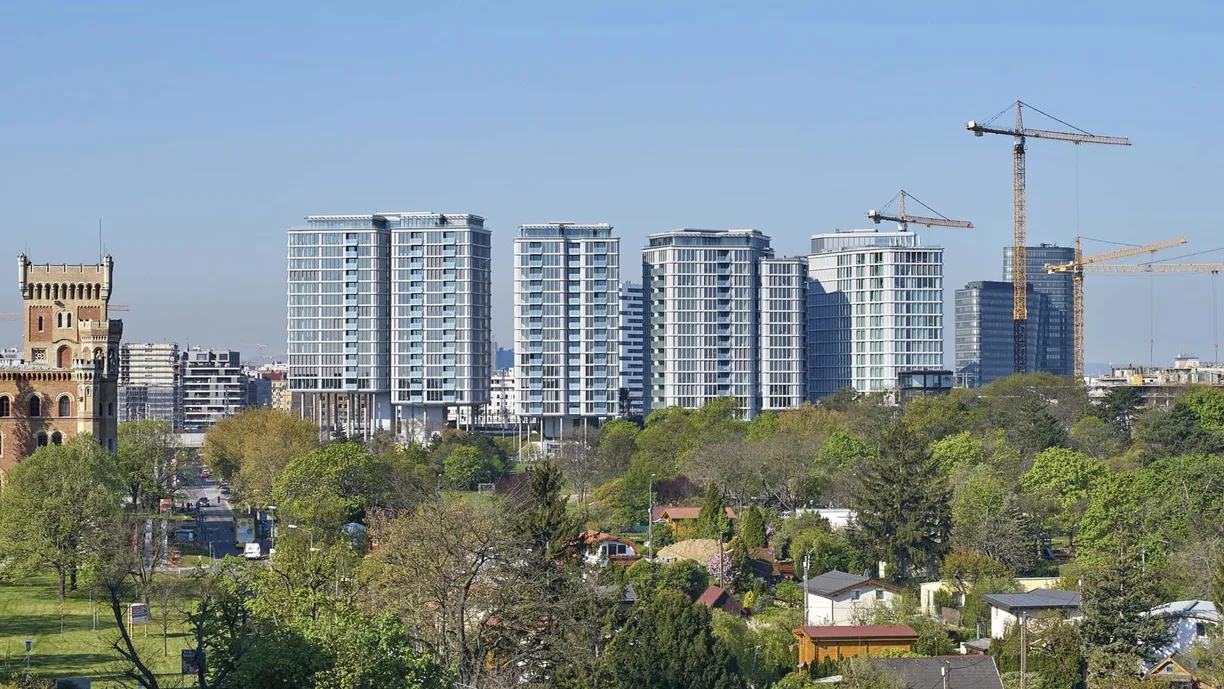 a city with a lot of tall buildings and cranes in the background .