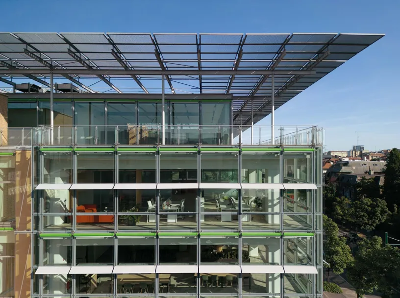 An aerial view of a large glass building with a roof