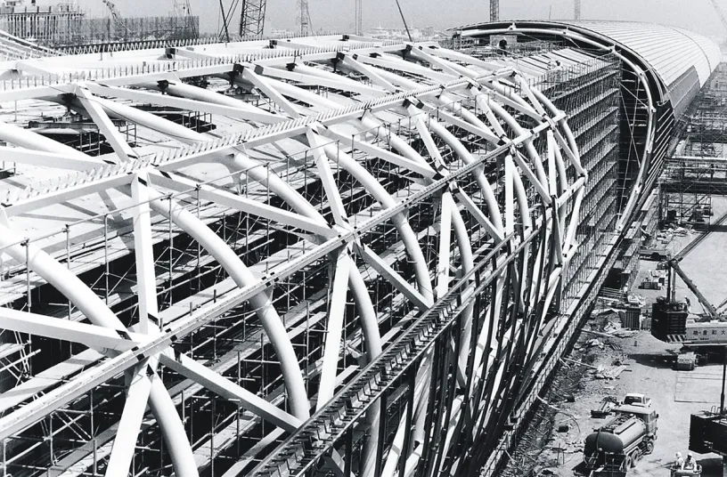 A black and white photo of a large building under construction