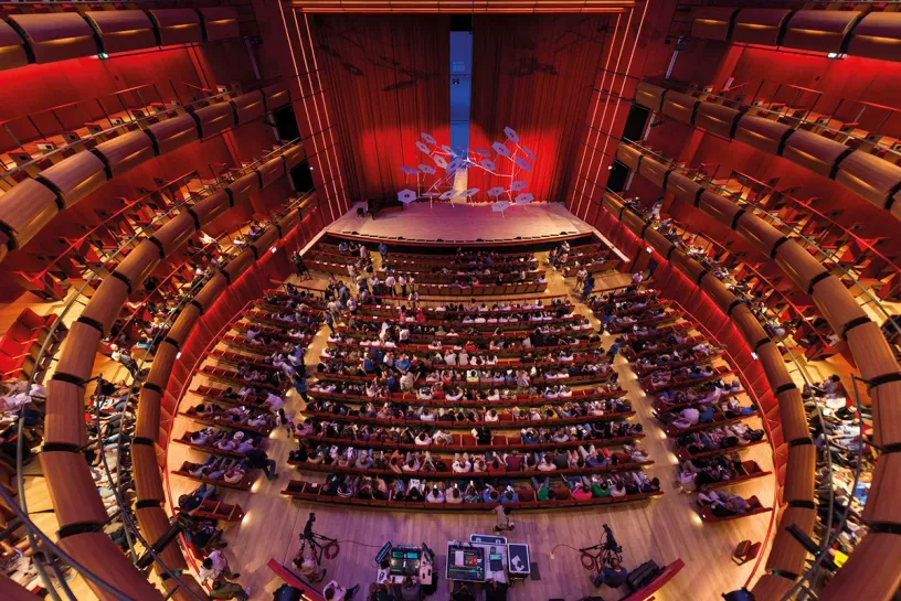 A large auditorium filled with people watching a concert