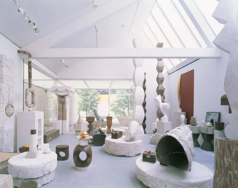 a large room filled with lots of sculptures in a museum .