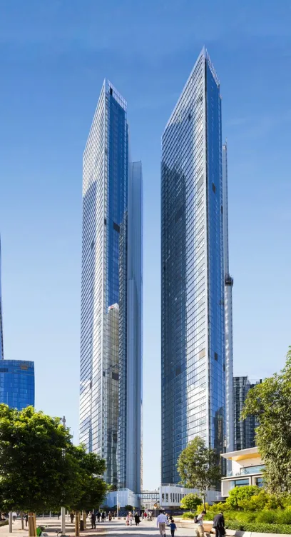 Two very tall buildings with a blue sky in the background