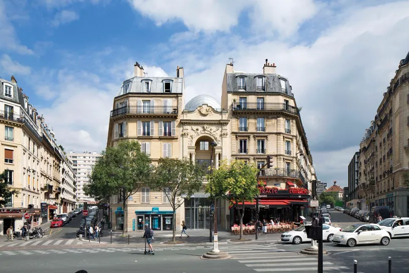A busy city street with a large building in the middle of it
