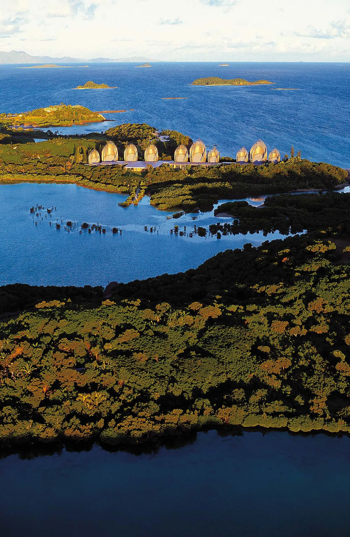 A row of tents sit on a small island in the middle of a body of water