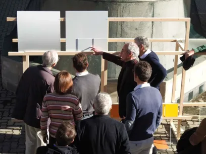 a group of people are standing around a wooden structure .