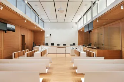 A courtroom with rows of benches and a projector screen