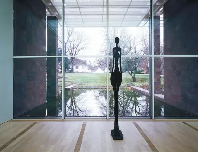 A statue of a woman standing next to a window in a museum