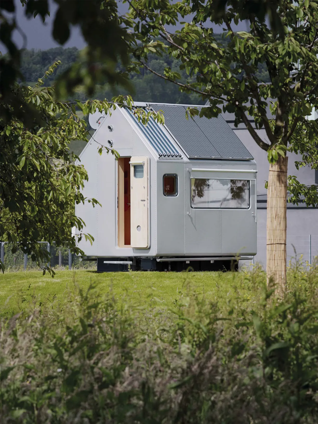 a small house is sitting in the middle of a grassy field