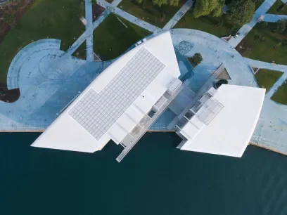 An aerial view of a large white building next to a body of water