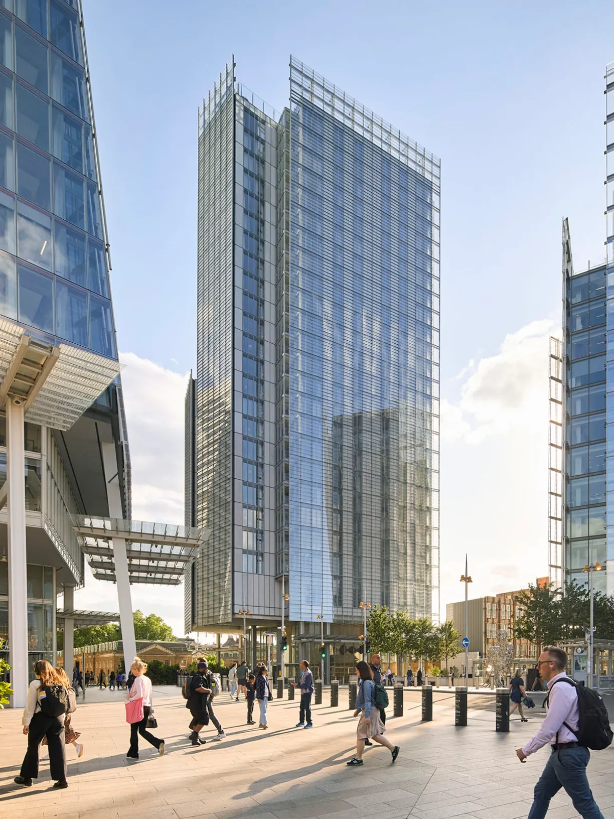 a group of people walking in front of a tall building