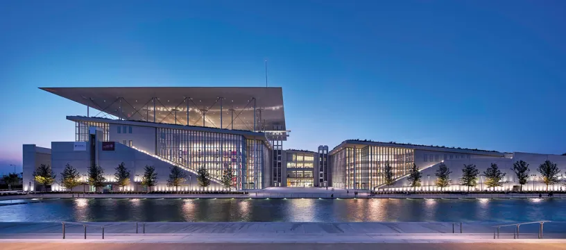 A large building with stairs leading up to it is next to a body of water