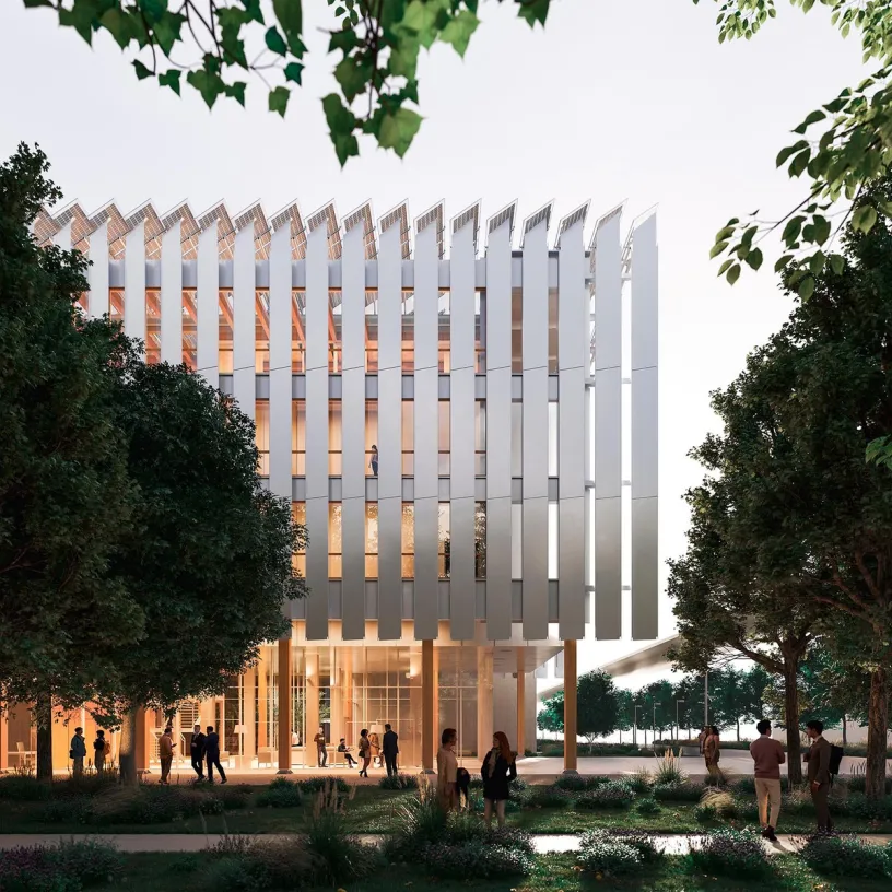 A modern building with vertical fins and a jagged roofline, glowing from within, surrounded by people in a landscaped park.