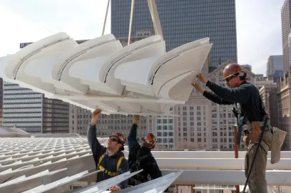 A group of construction workers are working on the roof of a building