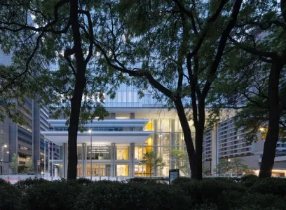 A large building with a lot of windows is surrounded by trees