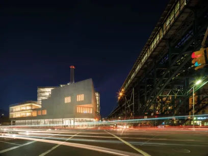a long exposure photo of a city street at night with a building in the background .