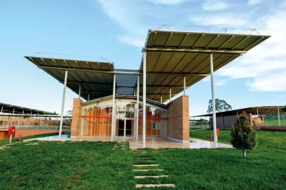A large building with a canopy over it is sitting on top of a lush green field