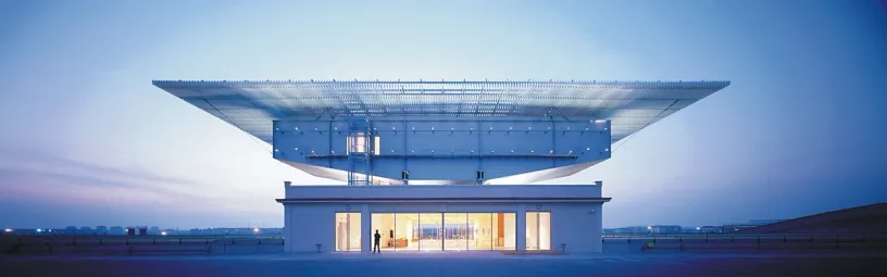 A large building with a large roof that is lit up at night