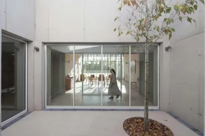 A woman is walking through a courtyard in front of a large window