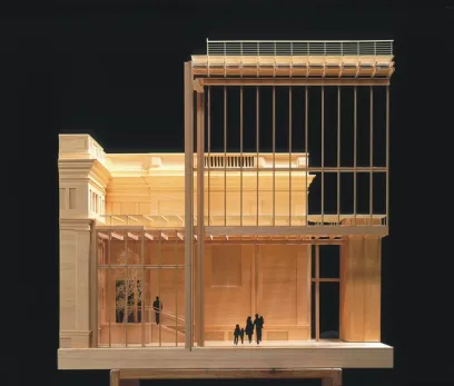 a wooden model of a building with a balcony and people standing in front of it .