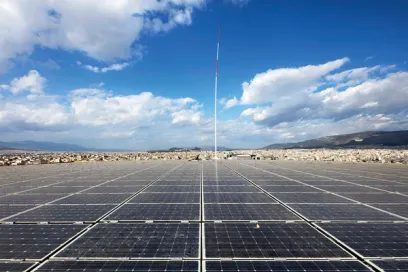 A row of solar panels sitting on top of a dirt field