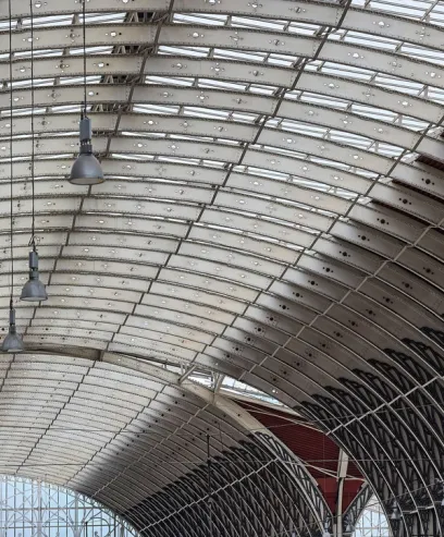 The ceiling of a building with a lot of windows and lamps hanging from it