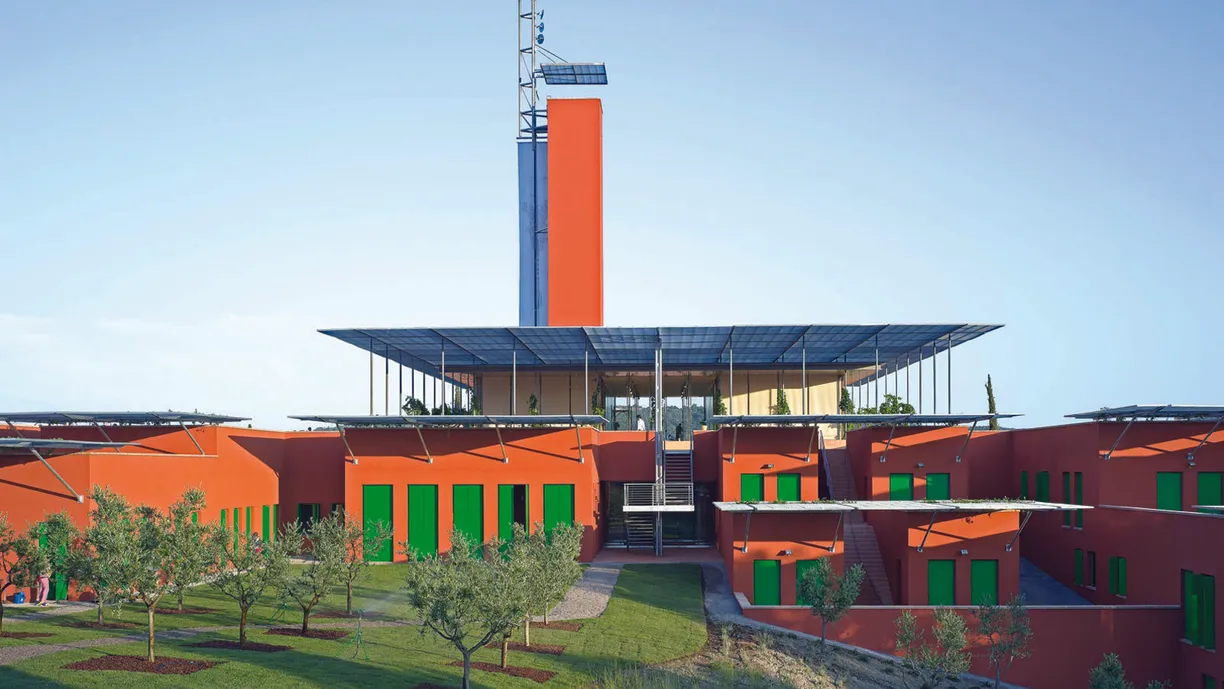 a large red building with a tower on top of it and green doors .