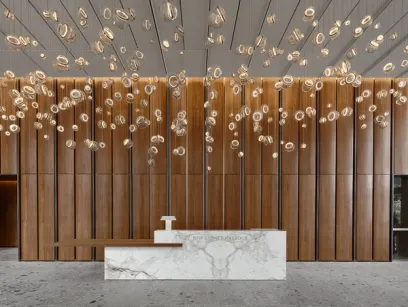 A lobby with a marble counter and a wooden wall