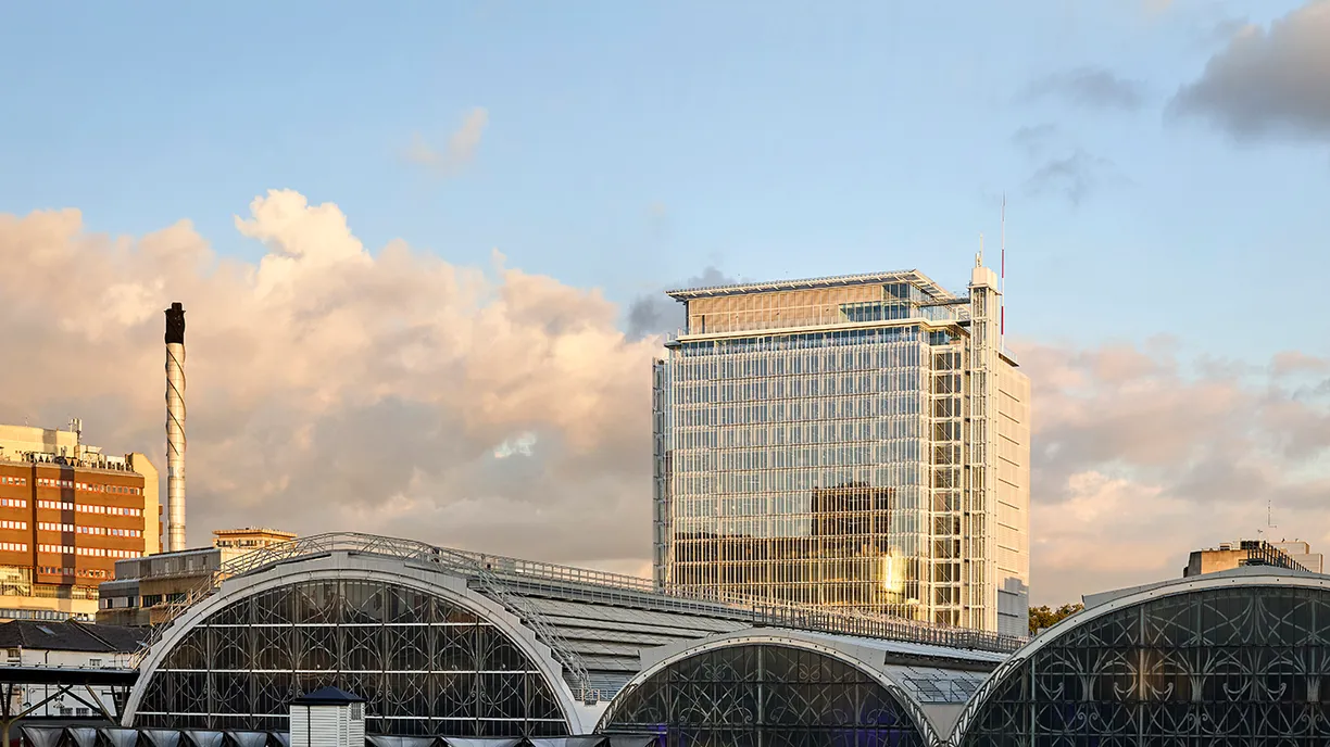 A large building with a lot of windows is in the middle of a city