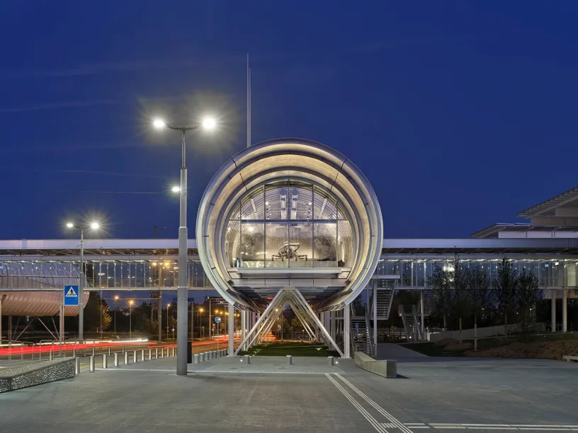 A large building with a bridge over it at night