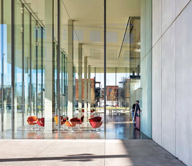 A large glass building with a lot of windows and chairs