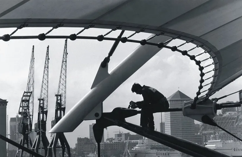 A black and white photo of a man working on a bridge