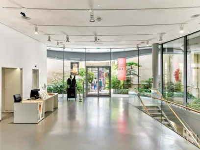 A large lobby with stairs leading up to the second floor of a building