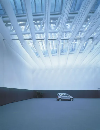 A car is parked in the middle of a large room