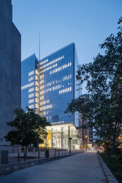 A tall building with a lot of windows is lit up at night