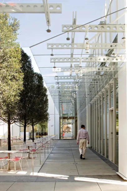 A man walks under a glass canopy with the letter l on it