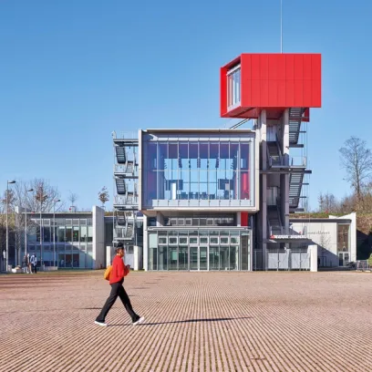 a woman is walking in front of a large building .
