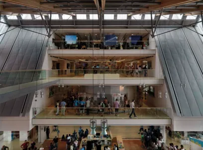 a group of people are standing on a balcony in a large building .